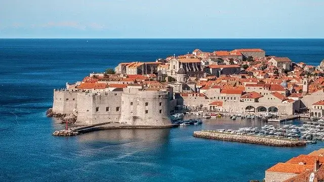 A photo of a seashore fortress city with sea water in the background and foreground