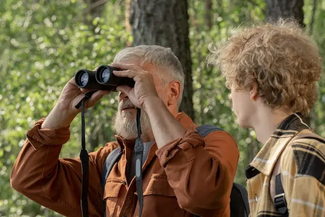 A son and a further in the field with the further holding binoculars